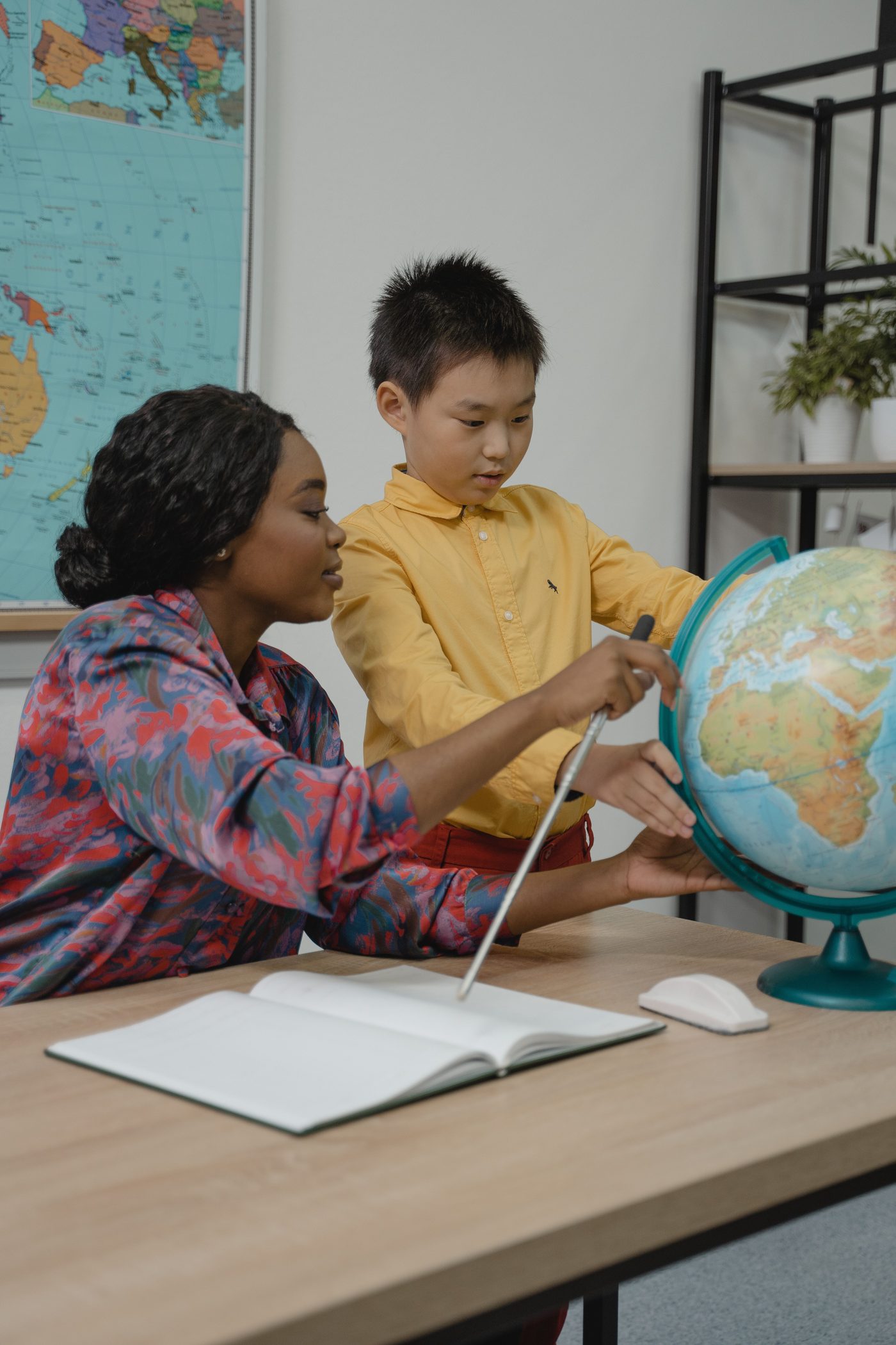 An adult and child learning together with a globe