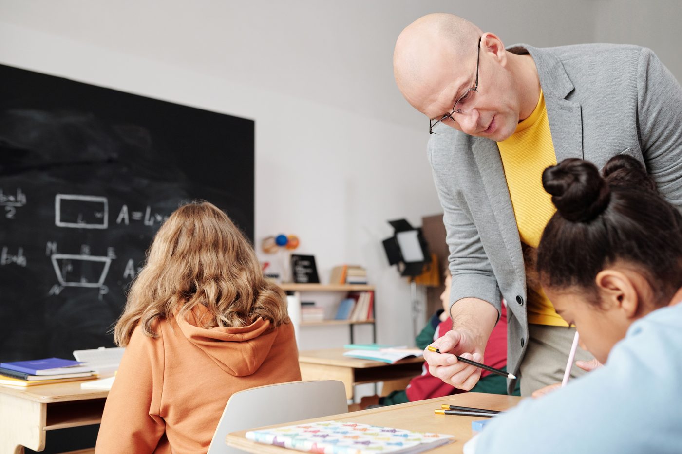 A teacher helping students in a classroom